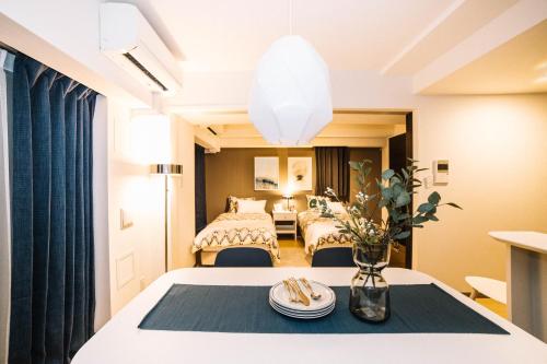 ein Hotelzimmer mit einem Tisch und 2 Betten in der Unterkunft Universal Haneda in Tokio