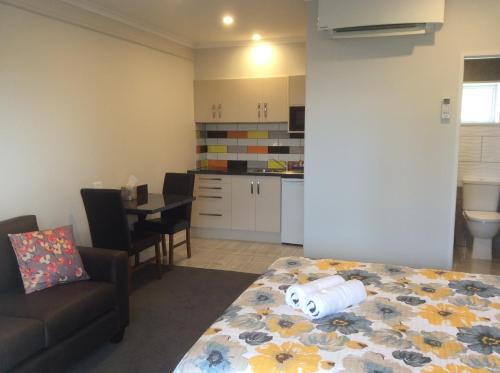 a living room with a bed and a kitchen at BigSky Motels in Omarama