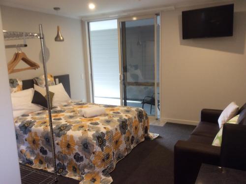 a bedroom with a bed with a flowered blanket at BigSky Motels in Omarama