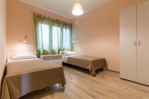 a bedroom with two beds and a large window at Apartments Hana in Pula