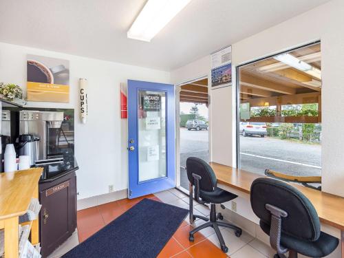 a kitchen with two chairs and a counter with a blue door at Motel 6 Gold Beach in Gold Beach