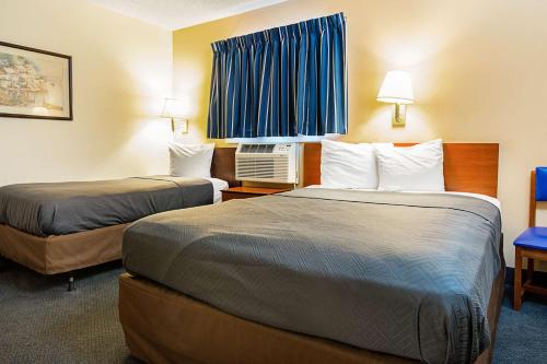 a hotel room with two beds and a window at Motel 6-Fayetteville, NC - Fort Liberty Area in Fayetteville