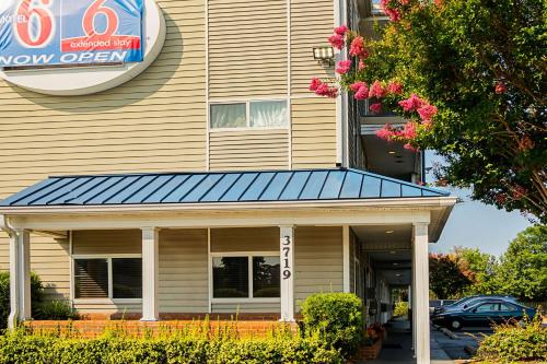 a building with a blue awning on it at Motel 6-Fayetteville, NC - Fort Liberty Area in Fayetteville