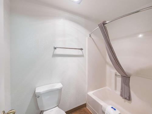 a white bathroom with a toilet and a bath tub at Motel 6 Gold Beach in Gold Beach