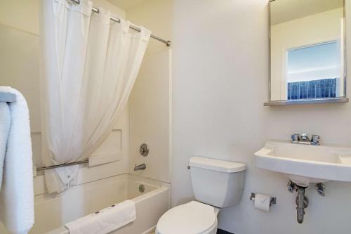 a white bathroom with a sink and a toilet and a tub at Motel 6-Fayetteville, NC - Fort Liberty Area in Fayetteville