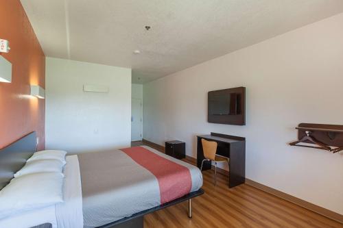 a hotel room with a bed and a desk at Motel 6-Bedford, TX - Fort Worth in Bedford
