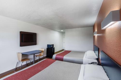a small room with a bed and a desk at Motel 6-Bedford, TX - Fort Worth in Bedford