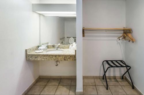 baño con lavabo, espejo y taburete en Motel 6-Pooler, GA - Savannah Airport en Savannah