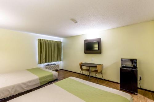 Habitación con 2 camas, TV y escritorio. en Motel 6-Troy, IL, en Troy