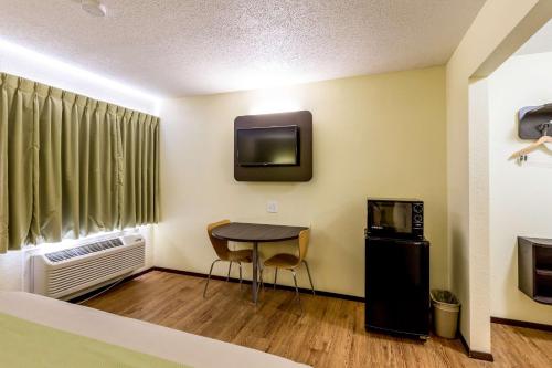 a room with a small table and a tv and a room at Motel 6-Troy, IL in Troy