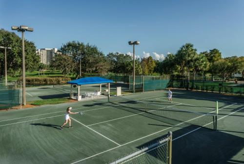 a man standing on a tennis court holding a racquet at Hyatt Regency Grand Cypress Resort in Orlando