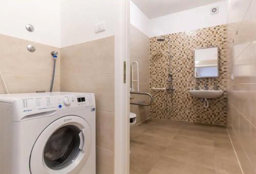 a bathroom with a washing machine and a sink at Apartments Hana in Pula