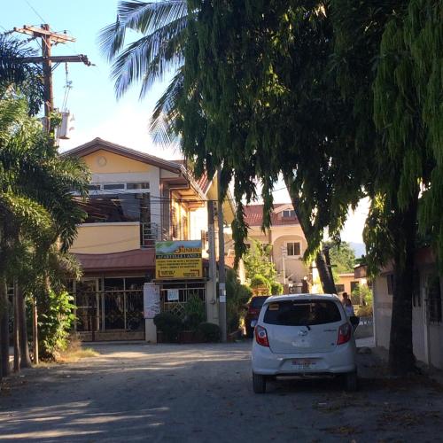 a white car parked in front of a building at Sunrise Apartelle in Olongapo