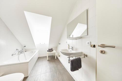 a white bathroom with a tub sink and a toilet at Wohnung 1- nur 5 min. zum Europapark in Ettenheim