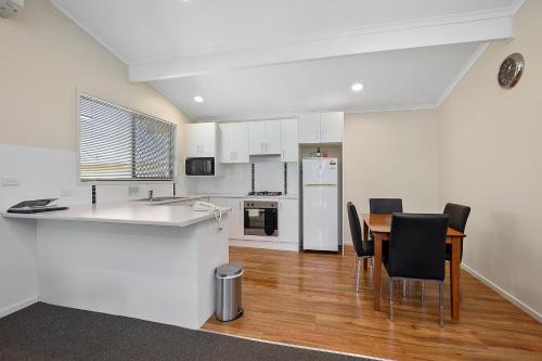 a kitchen and dining room with a table and chairs at Thunderbird Motel Yass in Yass