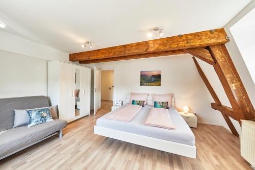 - une chambre avec un lit et un canapé dans l'établissement Wohnung 2 - nur 5 Fahrminuten vom Europapark, à Ettenheim