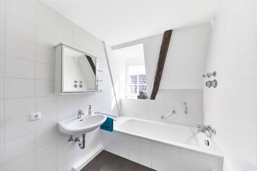 a white bathroom with a sink and a bath tub at Wohnung 2 - nur 5 Fahrminuten vom Europapark in Ettenheim