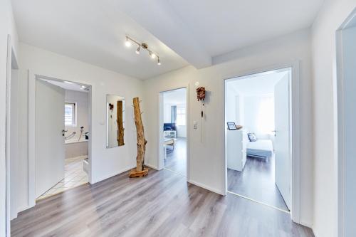 una sala de estar vacía con paredes blancas y suelo de madera. en Wohnung 4 - nur 5 min vom Europapark, en Altdorf