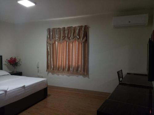 a bedroom with a bed and a window at Meaco Royal Hotel - Batangas City in Batangas City