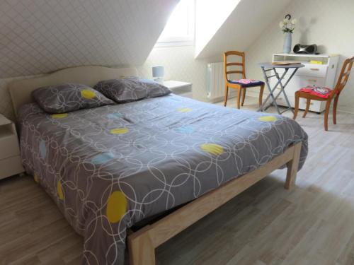 - un lit dans une chambre avec des chaises et une table dans l'établissement L'ESCALE - Résidence le Havre de Rotheneuf, à Saint-Malo