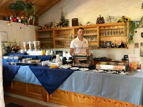 a man standing behind a counter in a kitchen at PAGA Hotel in Aidenbach