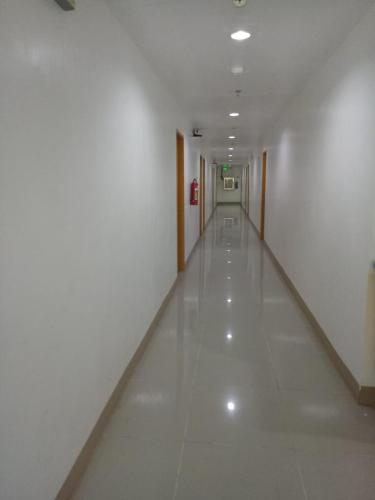 a hallway with white walls and a long white floor at Meaco Royal Hotel - Batangas City in Batangas City