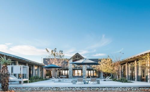 a courtyard with chairs and umbrellas in a building at Kruger Sunset Lodge in Hectorspruit
