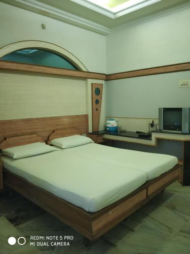 a large bed in a room with a tv at Krishna Lodge in Tiruchchirāppalli