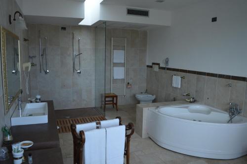 a bathroom with a tub and a toilet and a sink at Masseria Relais Del Cardinale in Pezze di Greco