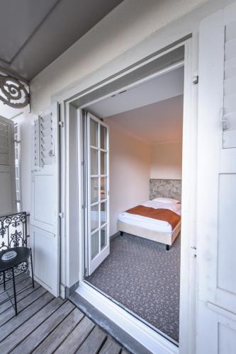 a bedroom with a bed and a door to a balcony at Bad Schauenburg in Liestal