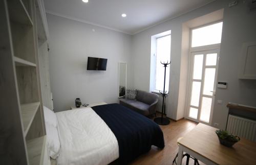 um quarto com uma cama, uma cadeira e uma mesa em Del Rey Comfort em Lviv