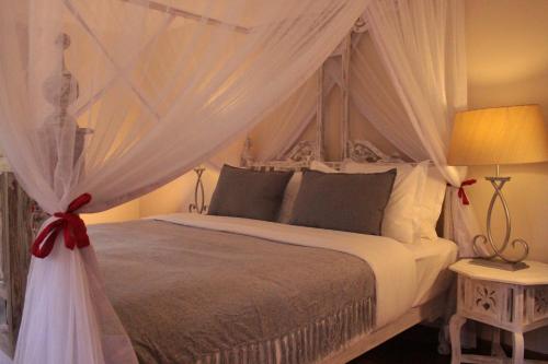ein Schlafzimmer mit einem weißen Bett mit Baldachin in der Unterkunft Le Rustique in Nanyuki