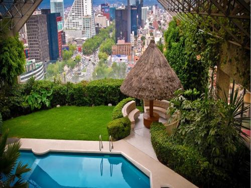 a large garden with a balcony overlooking a city at Sevilla Palace in Mexico City