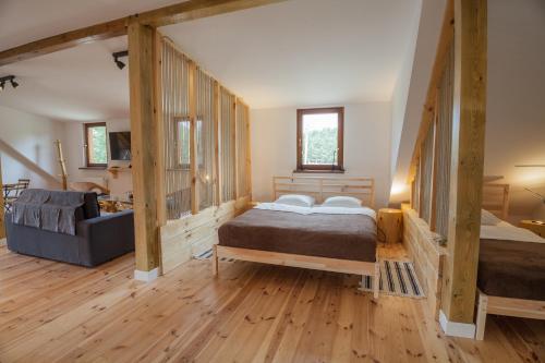 a bedroom with two beds in a room with wooden floors at Kompleks Małe Dolomity in Hucisko