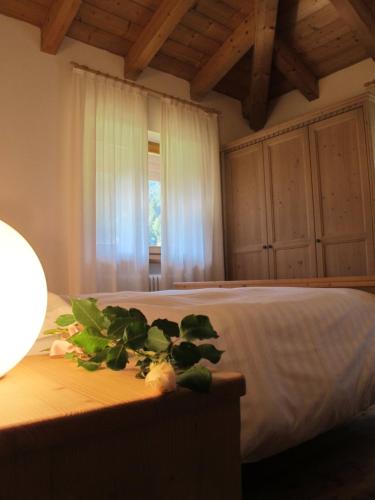 a bedroom with a bed with flowers on a table at Il Cardo Trentino in Bedollo