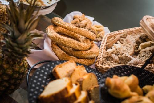 a table filled with bread and pastries and a pineapple at Sunshine Boutique Hotel by Estia in Malia