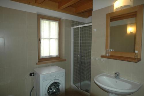 a bathroom with a sink and a washing machine at Appartamenti Al Lumin in Val di Zoldo