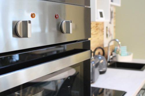 a kitchen with a stainless steel oven and a sink at Ferienwohnung Zum Alten Gaswerk in Gräfenhainichen