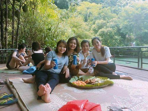 a group of girls sitting on a deck with drinks at Vagibi Hotel in Dong Hoi