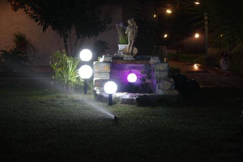 a fountain with lights in a yard at night at Villa Isabella in Marina di Grosseto