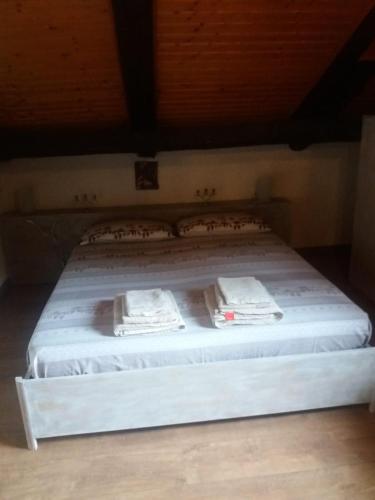 Una cama con sábanas blancas y toallas. en Maso del Capitel, en Commezzadura