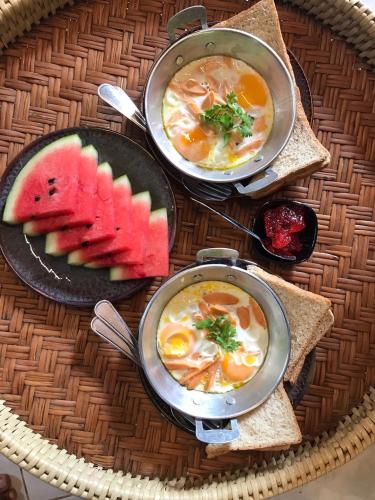 a table with three bowls of soup and a plate of food at Ashi Guesthouse Chiangdao in Chiang Dao