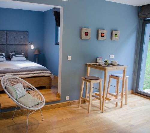a bedroom with a bed and two chairs and a table at La Suite Des Pervenches in Spa