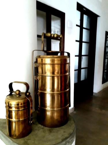 a couple of copper buckets sitting next to a door at "27" Spathodea- Oasis in the City in Colombo