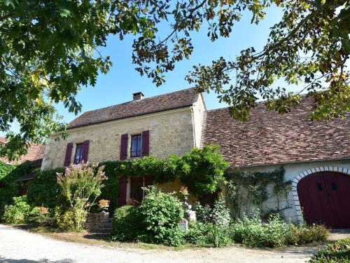 NanthiatにあるModern holiday home in Aquitaine with poolの赤いガレージ付きの古い石造りの家