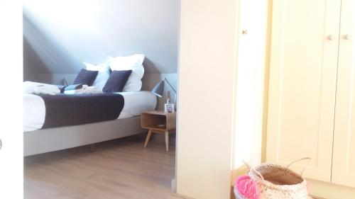 a bedroom with a bed and a table with a basket at Domus Portus in Dendermonde