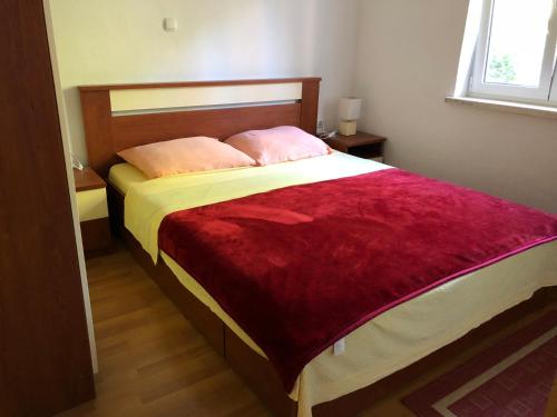 1 dormitorio con 1 cama grande y 2 almohadas rosas en Apartment Villa Nikola, en Blace