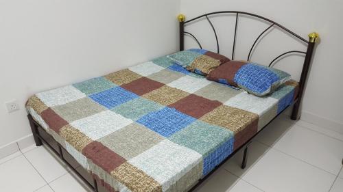 uma cama com uma colcha num quarto em F.A Guesthouse Pasir Gudang em Pasir Gudang