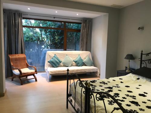 a bedroom with a bed and a chair and a window at Villa with Heated Pool and Jacuzzi close to Puerto Banus and Beach in Estepona