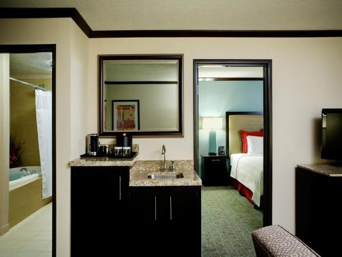 a hotel room with a bathroom with a bed and a sink at Crowne Plaza Anchorage-Midtown, an IHG Hotel in Anchorage